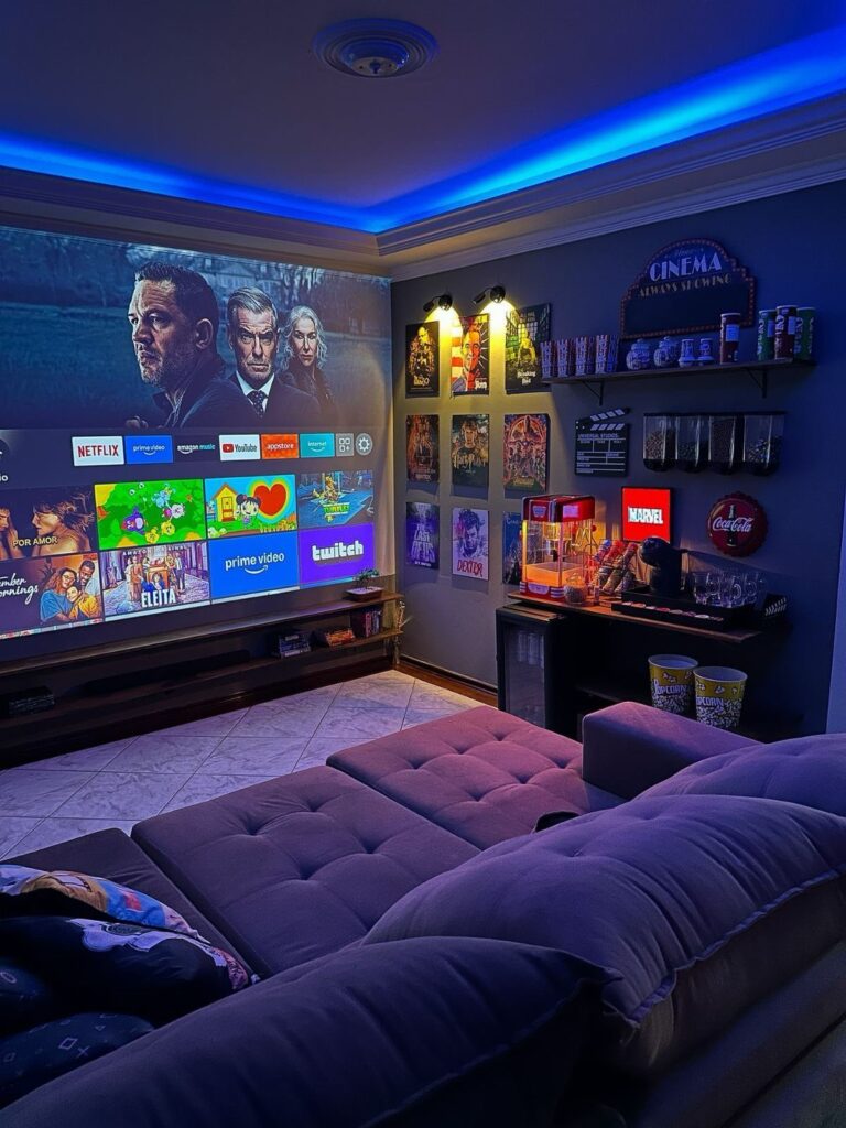 Small home cinema room with projection screen, purple sofa, and blue ambient lighting.